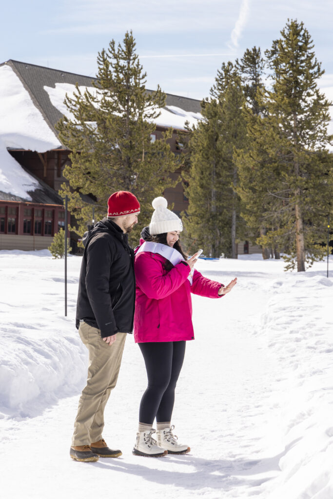 The couple sharing a quiet moment, framed by snow-covered pines.