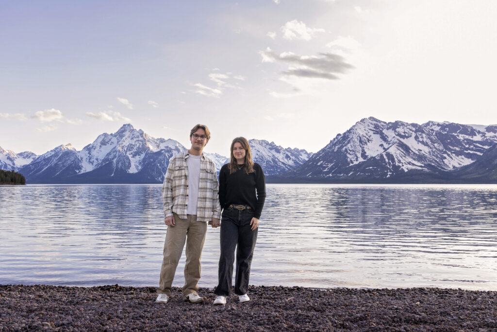 The couple walks hand-in-hand along Jackson Lake after the surprise proposal, soaking in the moment.