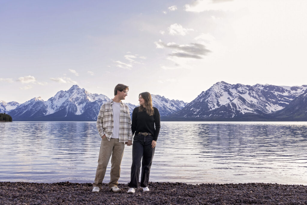 Couple walking hand-in-hand along the water’s edge