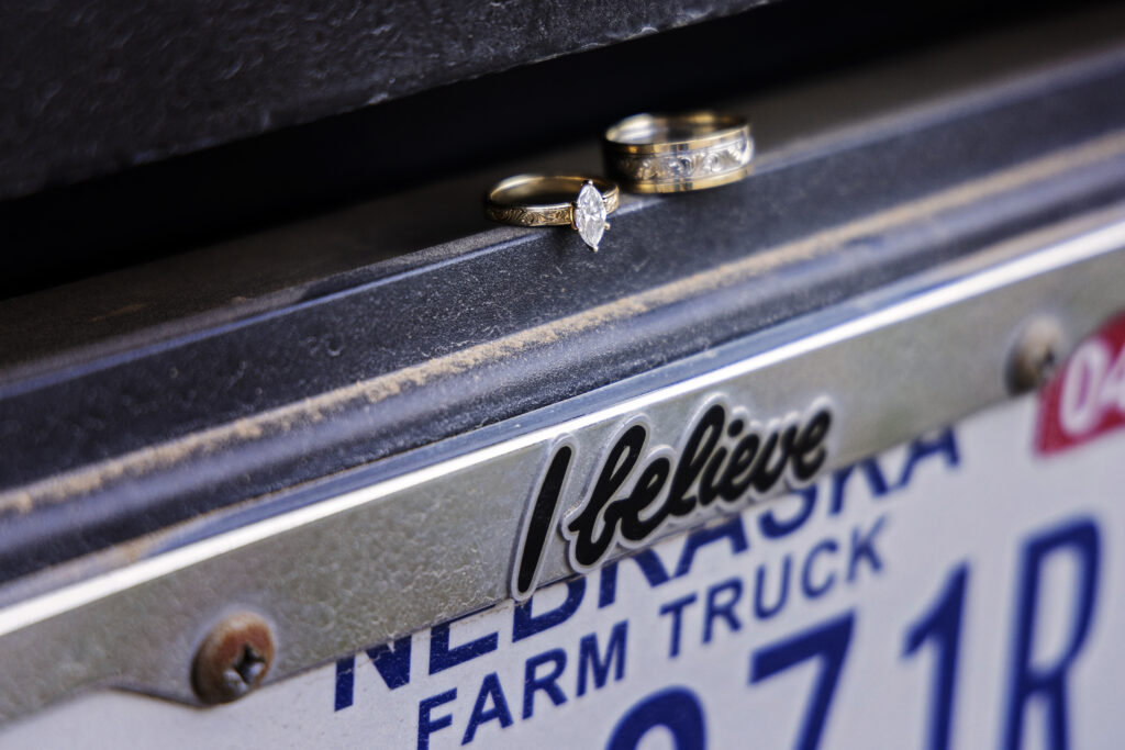 Wedding rings sitting on a pickup truck with a license plate.