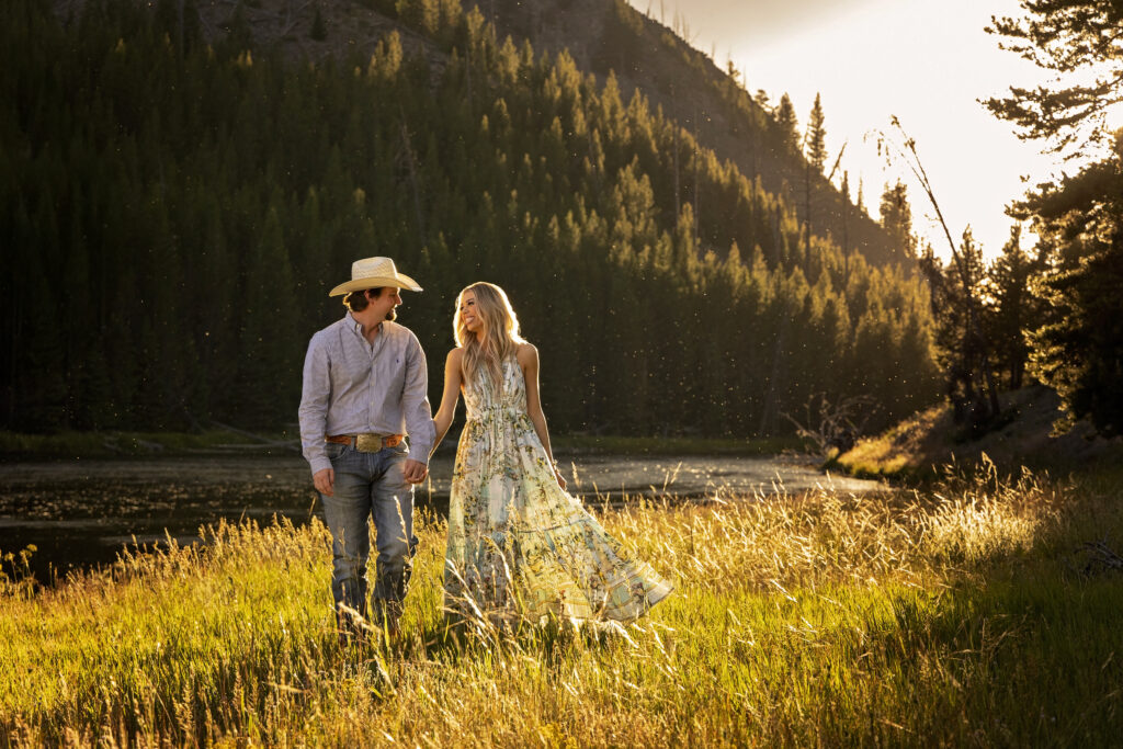 Engaged couple walking and smiling at sunset after their Montana surprise proposal in Yellowstone